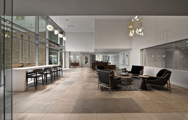 a large lobby with chairs and tables and a bar