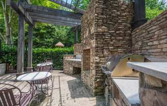 the patio has a pizza oven and tables and chairs