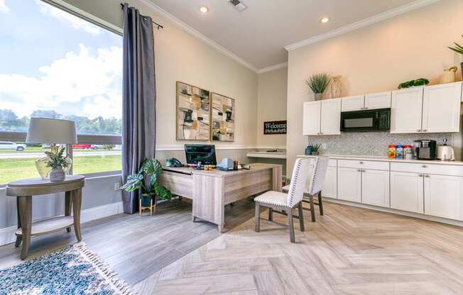 A modern kitchen with a desk and chair in the middle of the room.