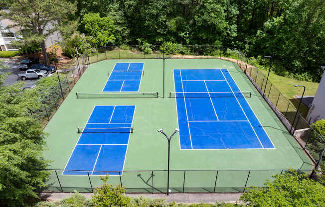 an aerial view of a tennis court with two blue tennis