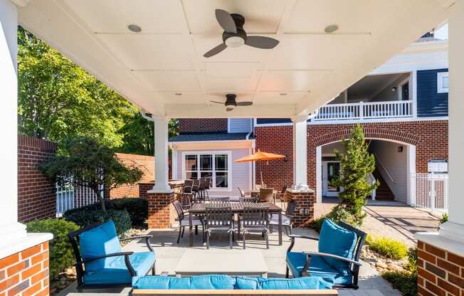 a patio with a table and chairs and a ceiling fan