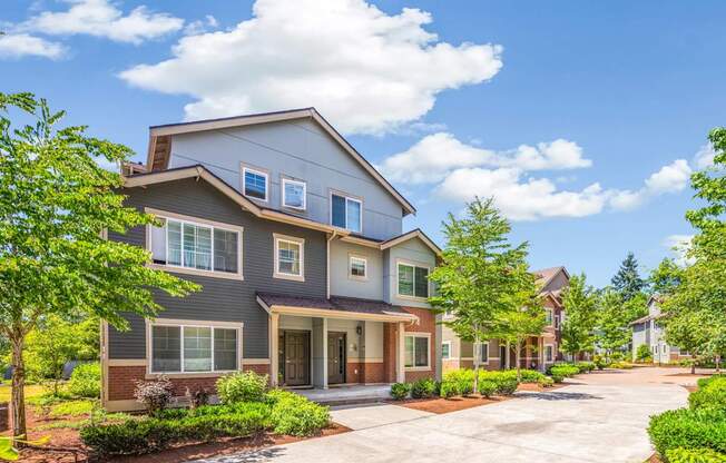 A modern house with a grey exterior and a large front yard.