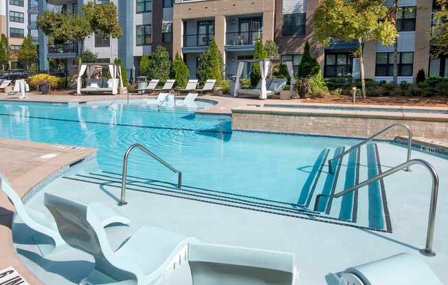 A swimming pool with a slide in front of apartment buildings.