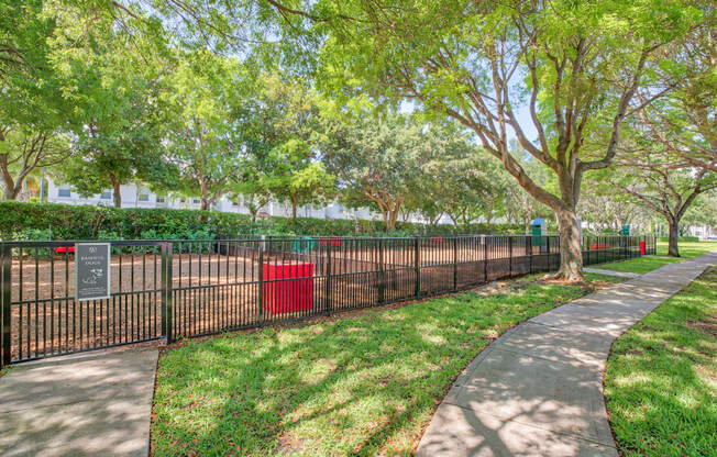 Large fenced in dog park in a shady tree area
