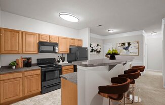 a kitchen with a bar and black appliances