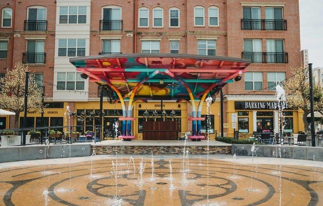 A fountain in front of a building with a canopy over it.