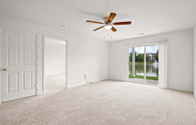 A room with a ceiling fan and carpeted floor.
