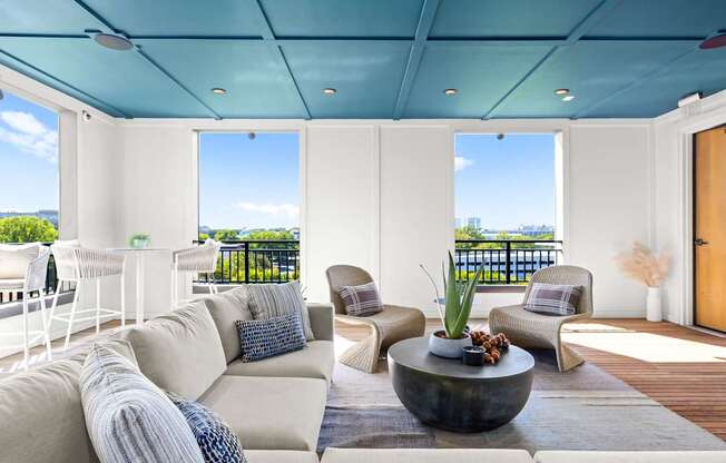 A modern living room with a large sofa and a view of the ocean.