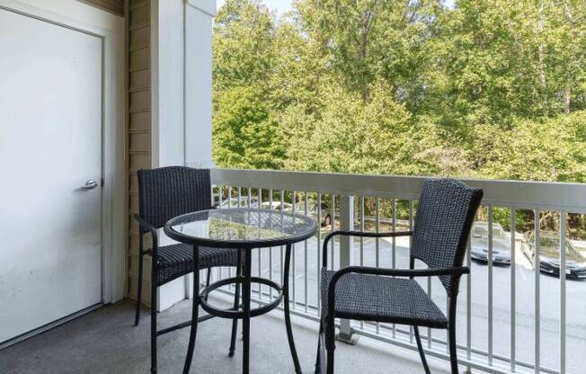 a patio with two chairs and a table on a balcony