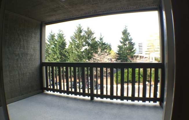 A balcony with a view of trees and buildings.