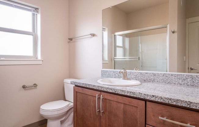 an empty bathroom with a toilet sink and mirror