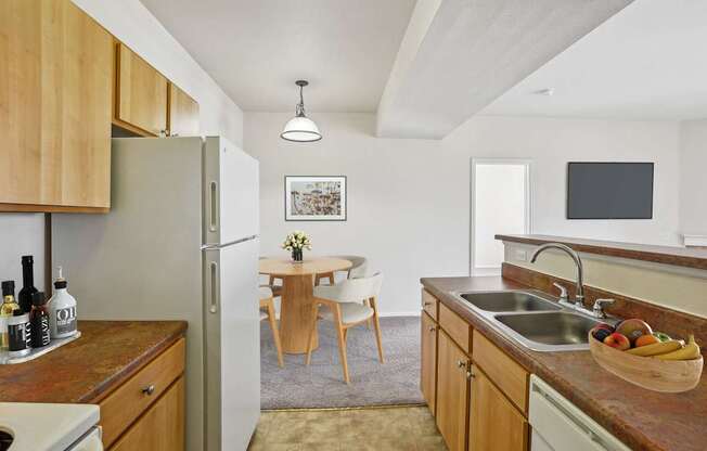 A kitchen with wooden cabinets and a refrigerator.