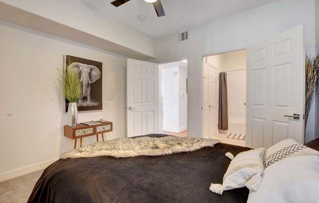 A bedroom with a large bed and a painting of an elephant on the wall.