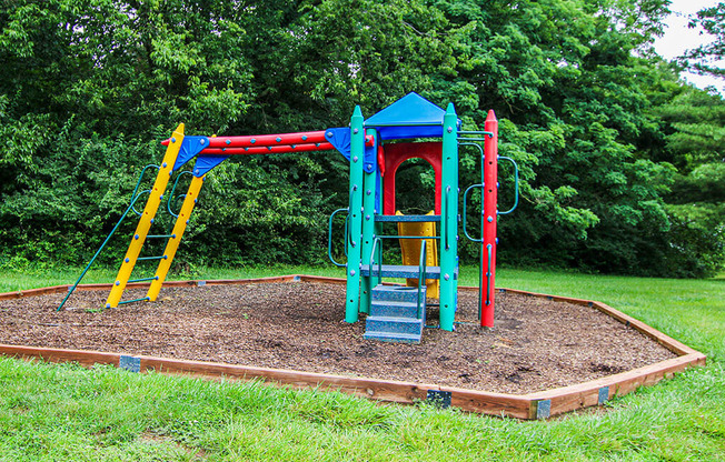 a playground with a colorful swing set in a park
