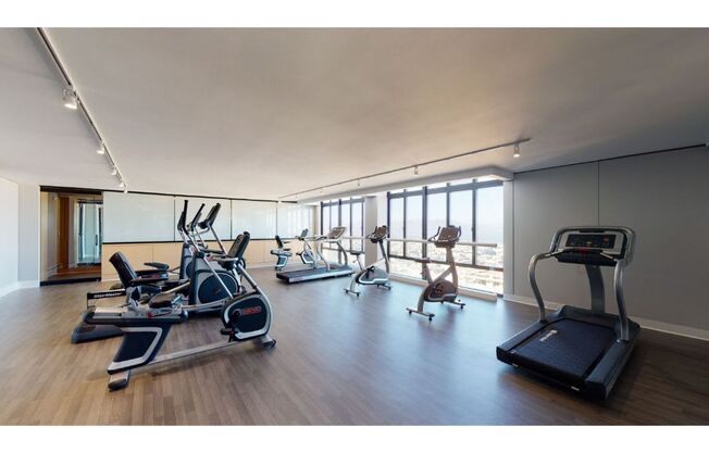 a room with a lot of exercise equipment and windows