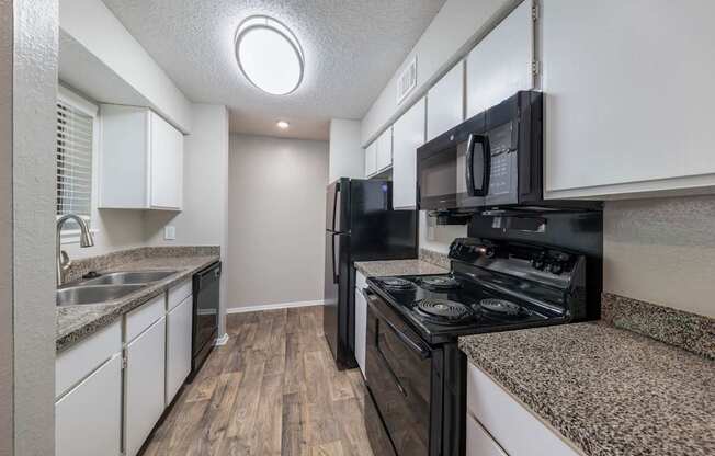 Crooked Stick kitchen with black appliances and white cabinets at Westdale Hills apartments