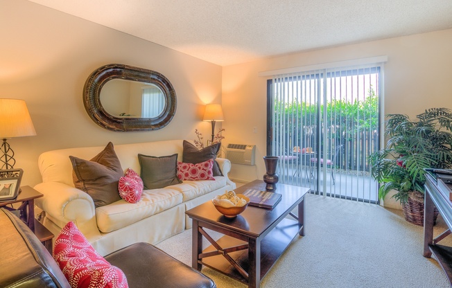 A living room with a white couch, a brown leather chair, and a wooden coffee table.