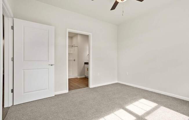 A room with a ceiling fan and a door.