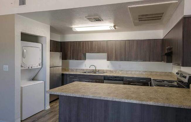 A kitchen with a refrigerator, sink, and countertop.