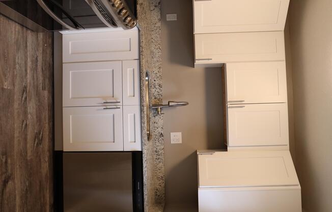 a kitchen with white cabinets and a refrigerator and a sink