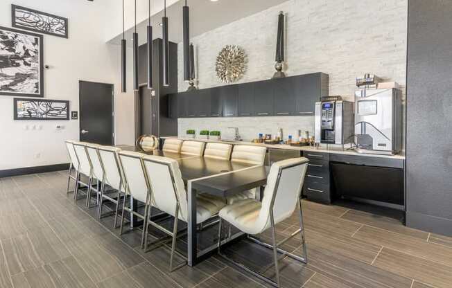 A coffee bar with a table and chairs and coffee machines and sink