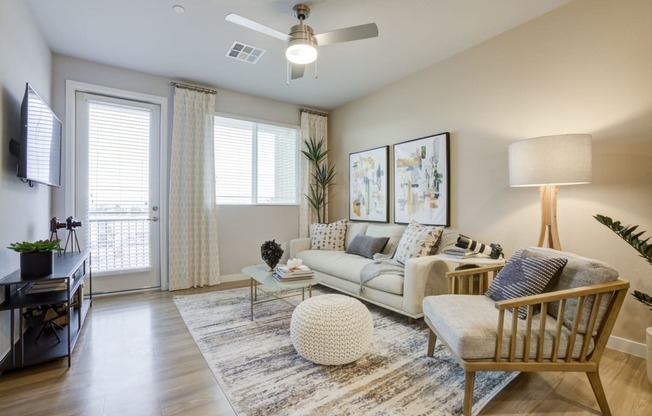 Pet-Friendly Apartments In South Scottsdale, AZ - Lucent Scottsdale - a living room with a ceiling fan and a door leading to a balcony