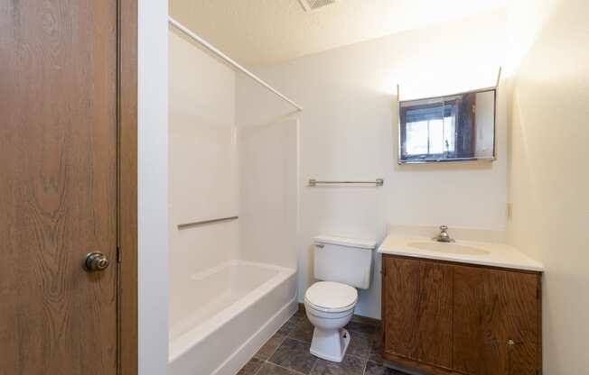 Mandan, ND Garden Grove Apartments. A bathroom with a toilet sink and bathtub