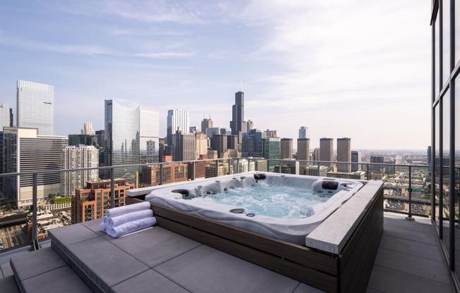 an outdoor jacuzzi on a balcony with a view of the chicago skyline