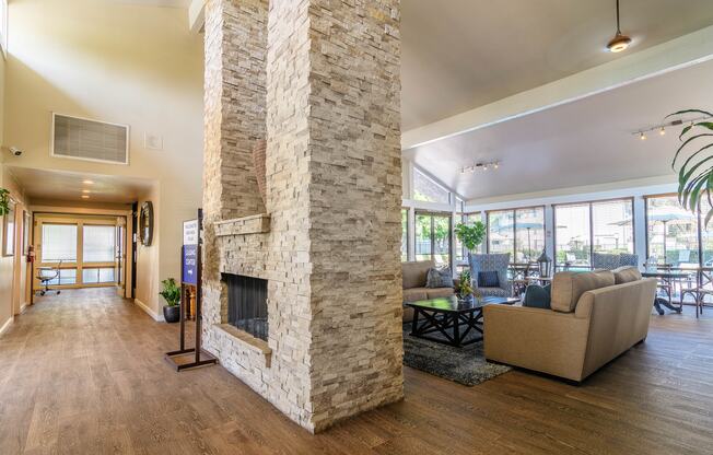 A living room with a stone fireplace and a couch.