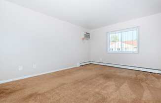 a bedroom with white walls and a window