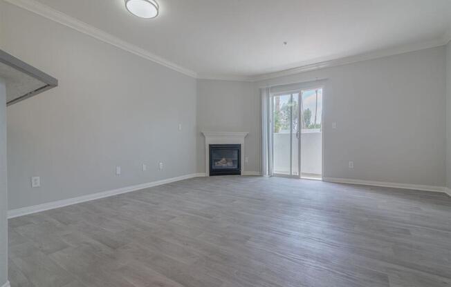 an empty living room with a fireplace and a sliding glass door at Warner Center Townhomes, Canoga Park, CA 91303