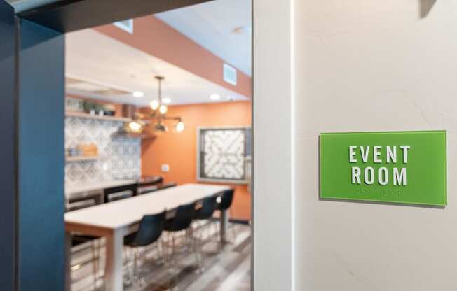 an event room with a table and chairs and a green sign that reads event room
