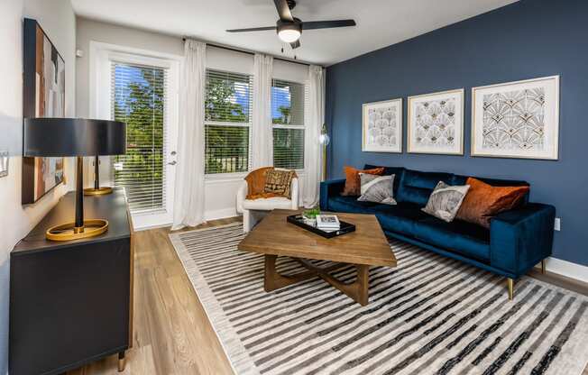 a living room with a blue couch and a wooden coffee table at The Alibi at Lake Lilly, Ocoee, FL