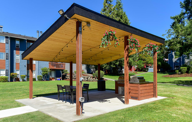 a covered patio with a grill and dining area
