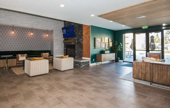 the lobby of a hotel with furniture and a fireplace