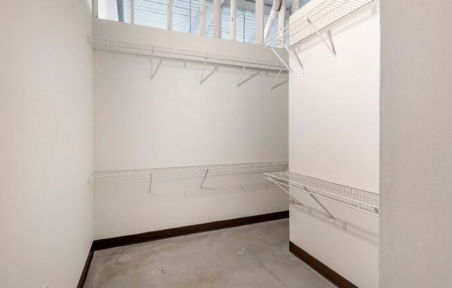 a room with white walls and a window and a closet with white shelves and racks at Highland Mill Lofts, North Carolina, 28205