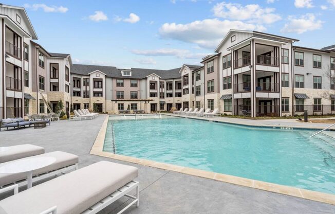 an empty pool with an apartment building in the background