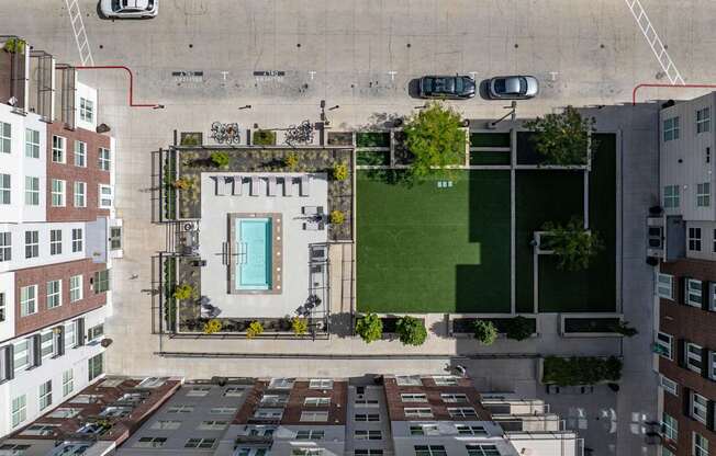 an aerial view of a building with green turf and a blue door on the roof