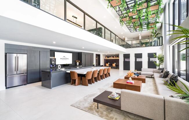 Grand clubroom with soaring ceilings, an oversized gathering island, and flexible seating areas designed for hosting, working, and unwinding.