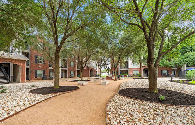 A courtyard with a dirt path and trees.