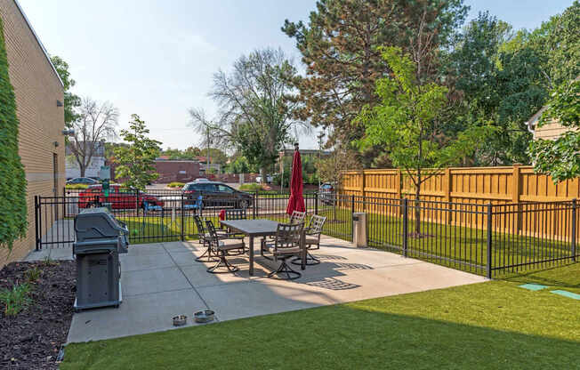 A black fence surrounds a picnic table in a park.