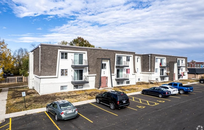 an apartment building with cars parked in front of it