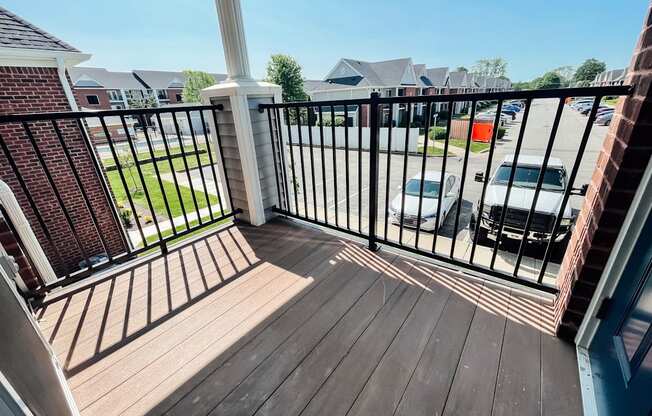 a balcony with a wooden floor and a black railing with a balcony fence