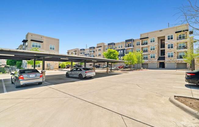 A parking lot with cars and a building in the background.