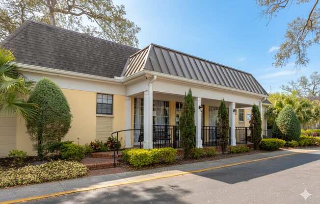 A house with a black roof and white columns.