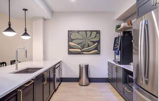 A modern kitchen with a large painting on the wall.