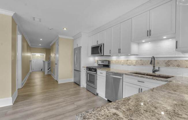 A kitchen with granite countertops and stainless steel appliances at The Knights @ 506 Delaware Apartments, Buffalo