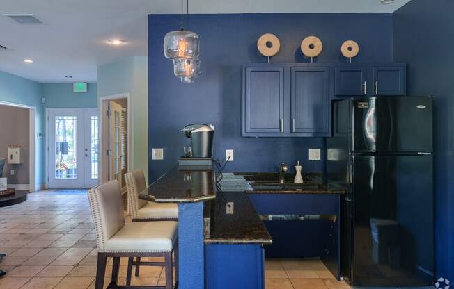 a kitchen with blue cabinets and a black counter top