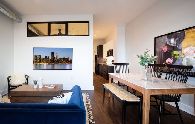 a living room and dining room with a blue couch and a wooden table at The Irvine, Philadelphia, PA