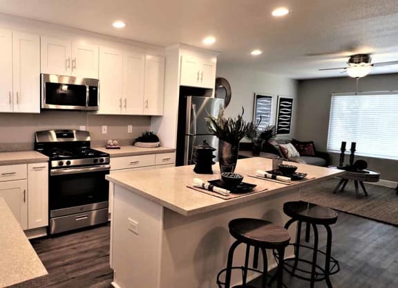 Thumbnail 5 of 17 - Pet Friendly Apartments in Fremont CA-Pinebrook Apartments Modern Kitchen with Gorgeous Lighting, Matching Stainless Steel Appliances, and Spacious White Cabinets